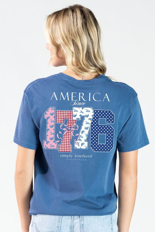 Woman wearing a blue Simply Southern t-shirt with 'America Since 1776' design on the back.  Available at La Boutique in Reidsville, NC